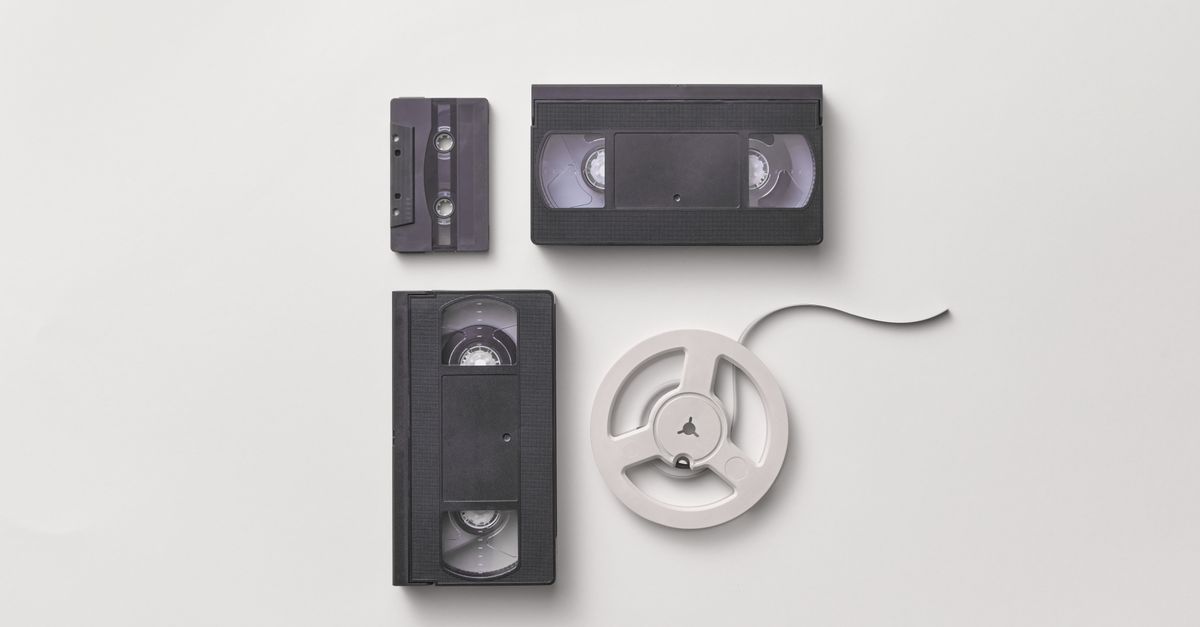 Collection of vintage audio and video tapes including VHS and cassette on a white background.
